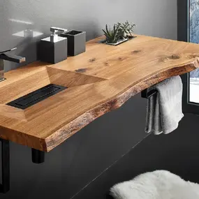 Waschtisch aus Massivholz mit modernem Wasserhahn und Ausblick auf verschneite Landschaft.