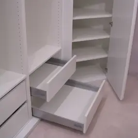 Moderner weißer Kleiderschrank mit offenen Türen, Schubladen und Regalböden.